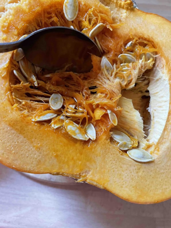 Seeds being removed from Pumpkin with spoon