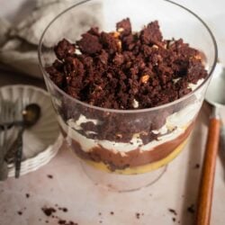 Brownie Trifle in a large dish with spoons and plates for serving to side