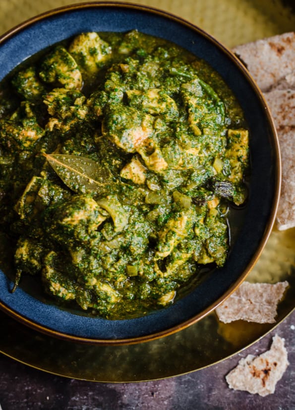 Palak Chicken in a bowl with a chappati to side