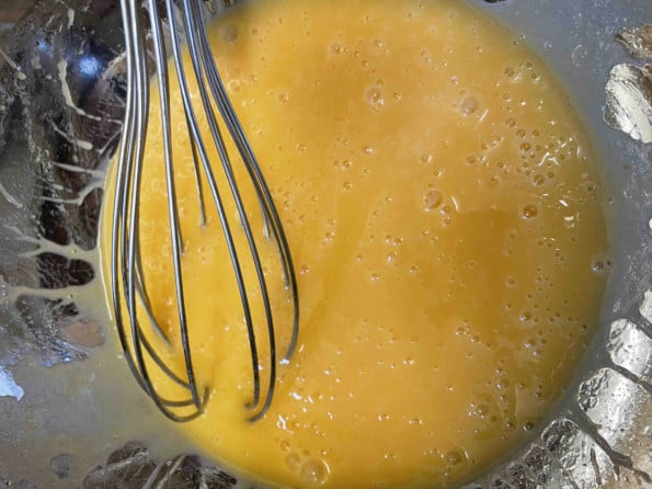 Eggs and oil whisked together in bowl
