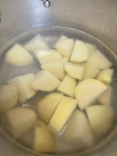 Potatoes in salted water in pot