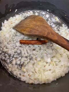 Onion and Spices frying in Ghee and Oil in pot