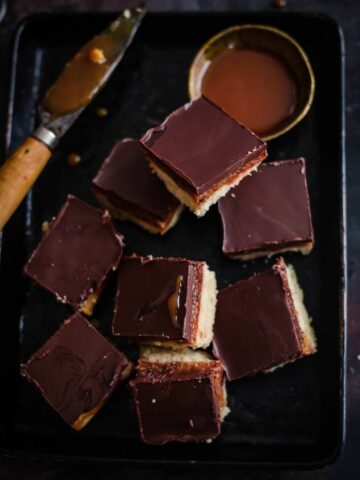 Millionaire Shortbread with Caramel and Knife in a rectangular black plate