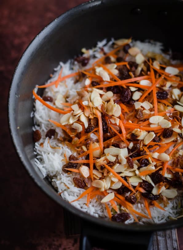 Jewelled Rice in a pot with carrots, flaked almonds and sultanas on top
