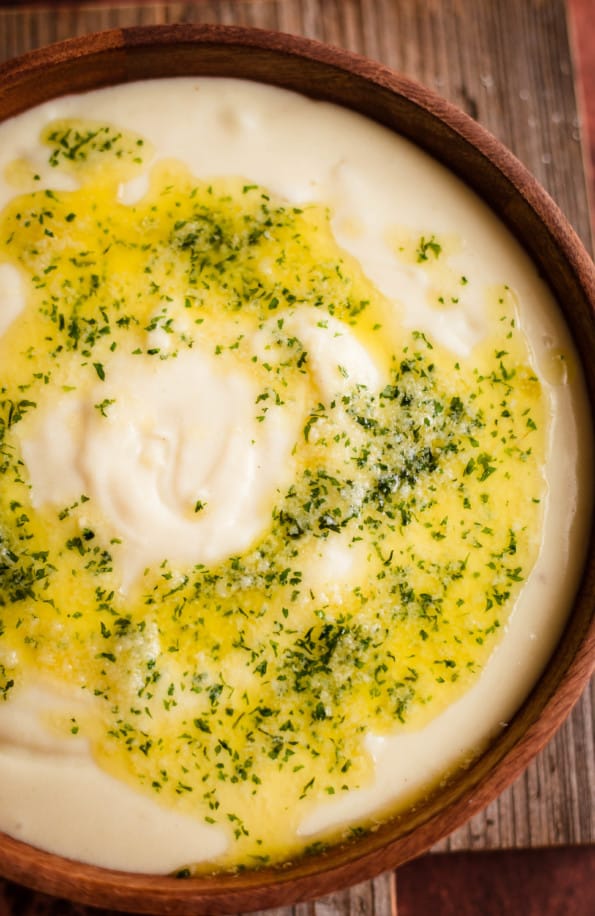 Garlic Mashed Potatoes in a bowl with Parsley Garlic Butter on top