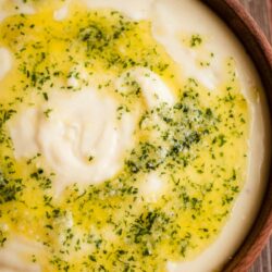 Garlic Mashed Potatoes in a bowl with Parsley Garlic Butter on top