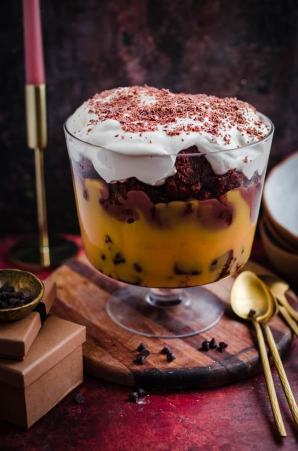 Brownie Trifle in a footed trifle dish with gold spoons and presents to side