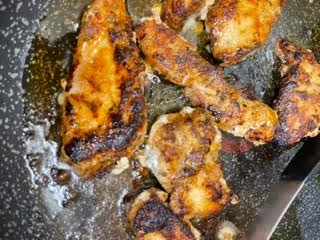 Chicken Tenderloin frying in a pan with butter and oil