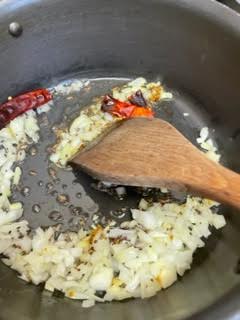 Onion and Red Chilli in pot with wooden spoon