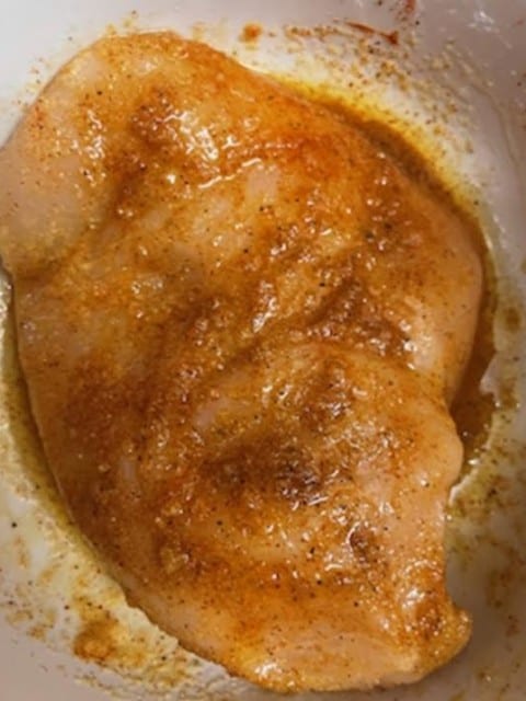Chicken breast in marinade in bowl