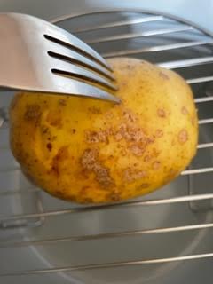 Potato being pierced with fork