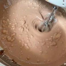 Nutella, Cream and Condensed milk in a bowl being whsiked with hand mixer