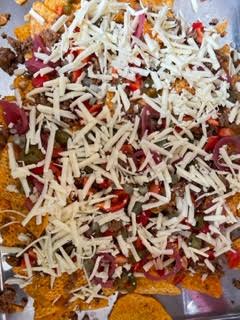 Grated Cheese added on top of Nachos in oven tray