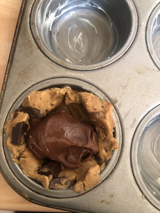 Nuetlla added to cookie dough in muffin hole tin