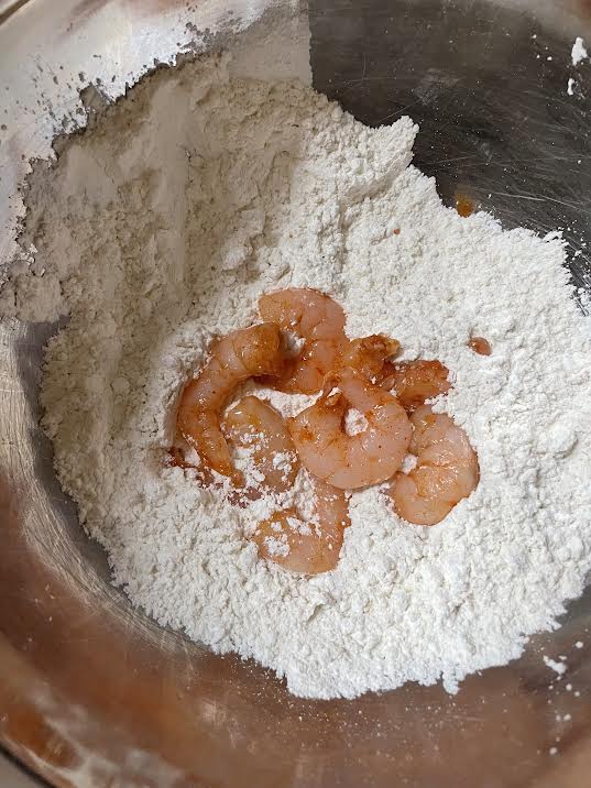 Shrimp in seasoned flour in bowl