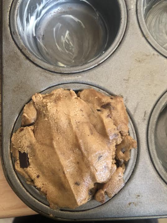 Remaining cookie dough added on top of nutella cookie cup in tin