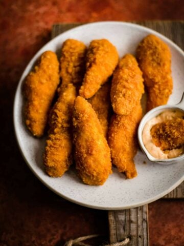 Chicken Goujons on a plate with dipping sauce to side