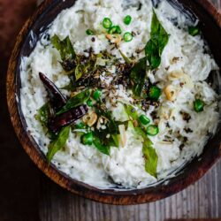 Curd Rice in a bowl on top of chopping board