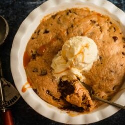 2 Minute Microwave Cookie Dough in a dish with an ice cream scoop on top
