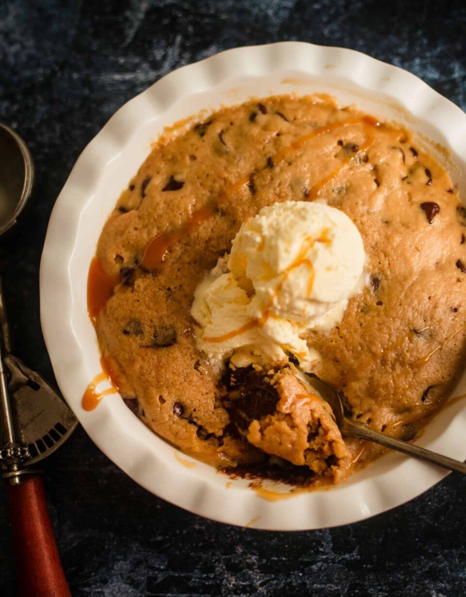 2 Minute Microwave Cookie Dough in a dish with an ice cream scoop on top