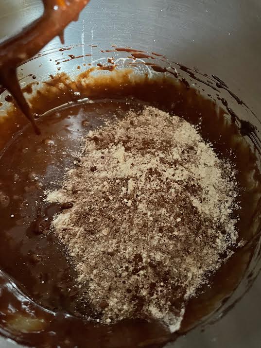 Flour and Cocoa added to chocolate batter in bowl