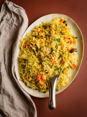 Veg Pulao in a dish with a towel to side