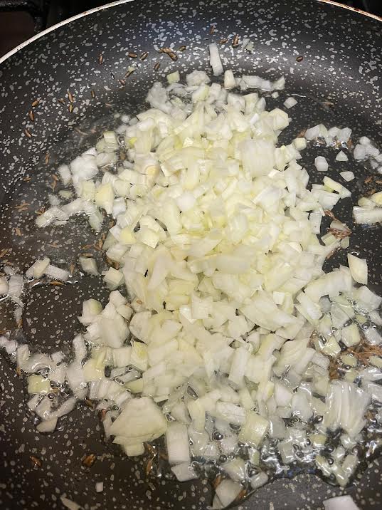 Onions cooking in oil and butter in pan