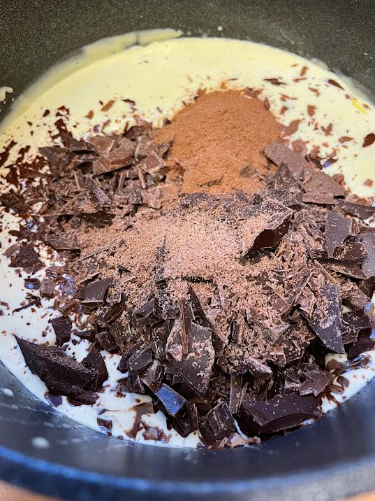 Chocolate ad malt powder added to cream in pot