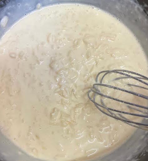 Cheese being stirred into cream and milk