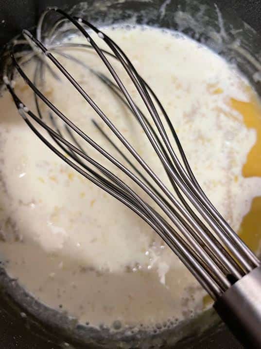 MIlk added to pot with whisk 