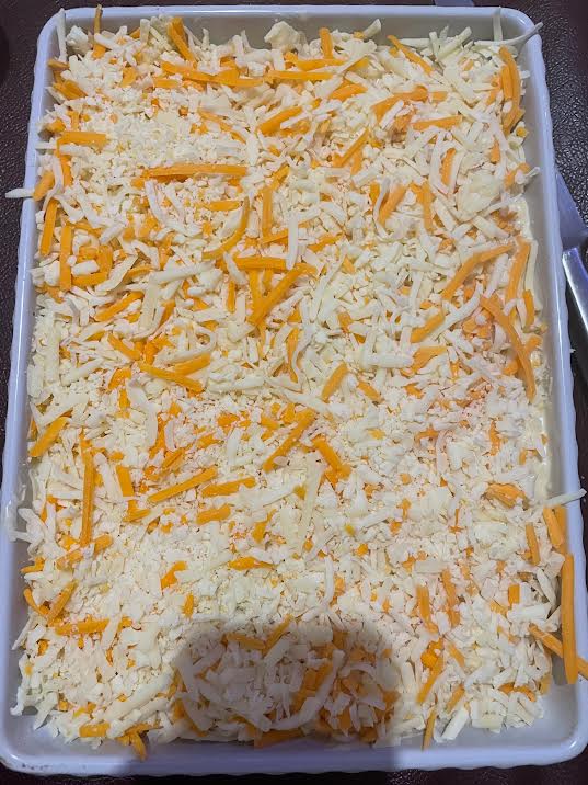 Cheese added to top of Macaroni in baking dish