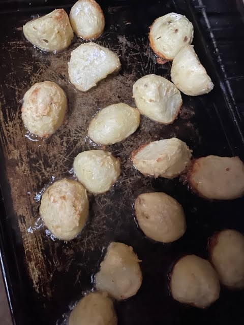 Potatoes in oven tray, turned midway