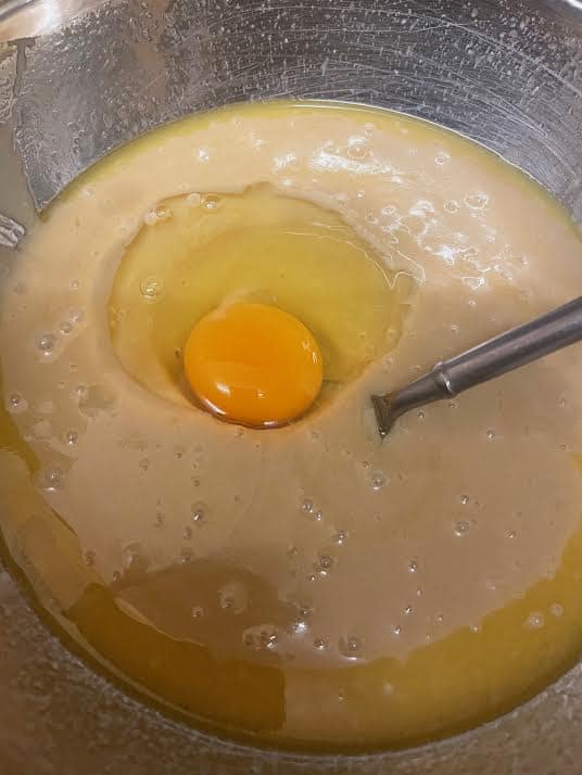 Egg added to bowl with condensed milk