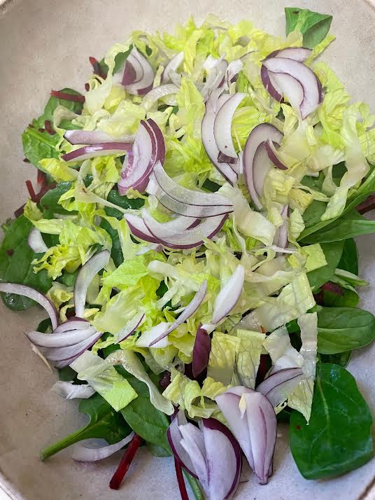 Red onion added to salad bowl