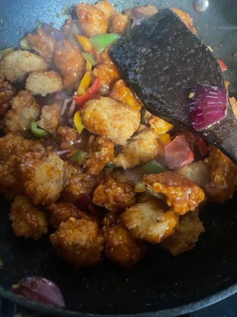 Fried Chicken added to peppers in wok
