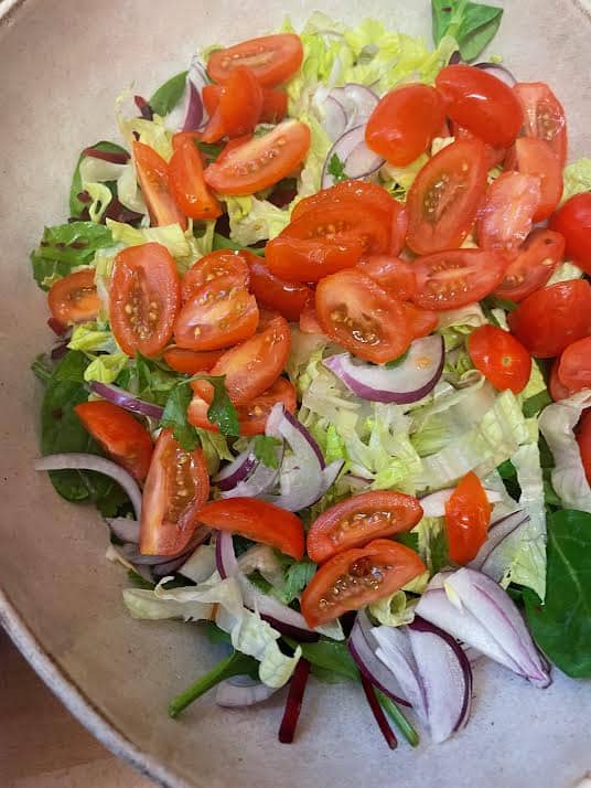 Tomatoes added to salad bowl