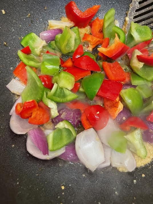Chopped peppers added to wok