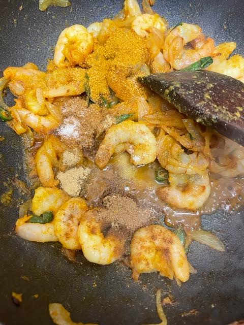 Spices added to prawns in wok