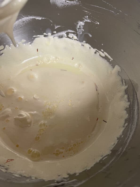 Milk added to egg yolk mixture in bowl