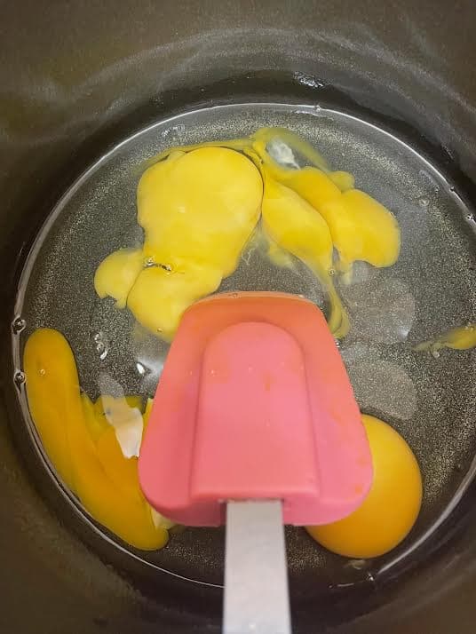 Eggs in a pot with rubber spatula