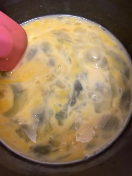 Eggs being stirred with spatula in pot