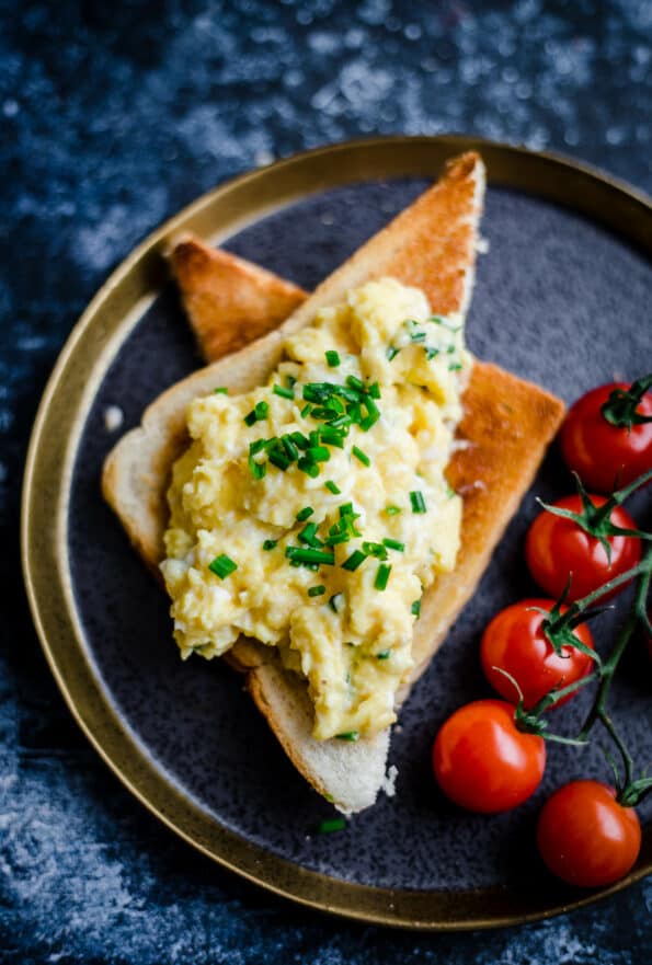 scrambled eggs with chives and tomatoes on plate
