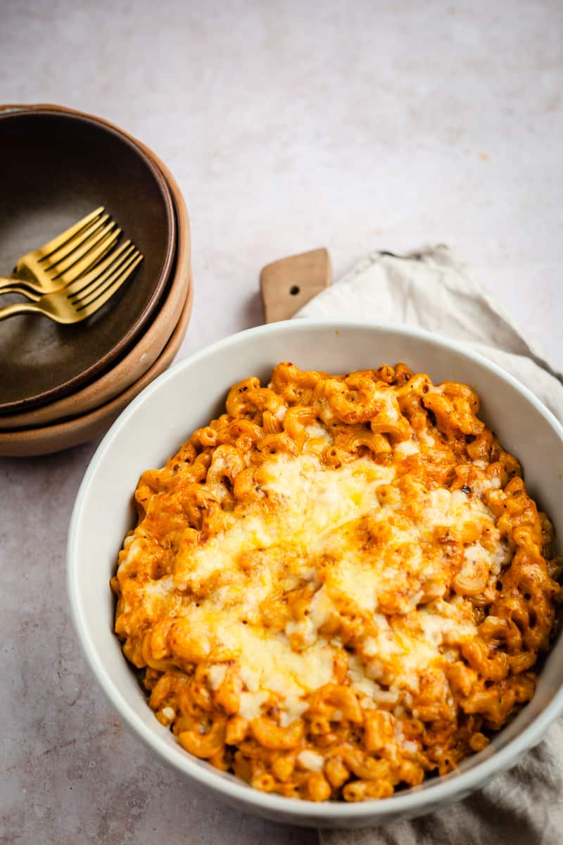 Masala macaroni in dish with bowls to side