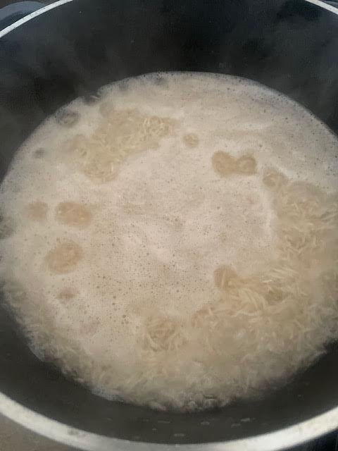 Rice and water in pot with some water evaporated
