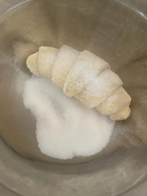 croissants in a bowl of sugar