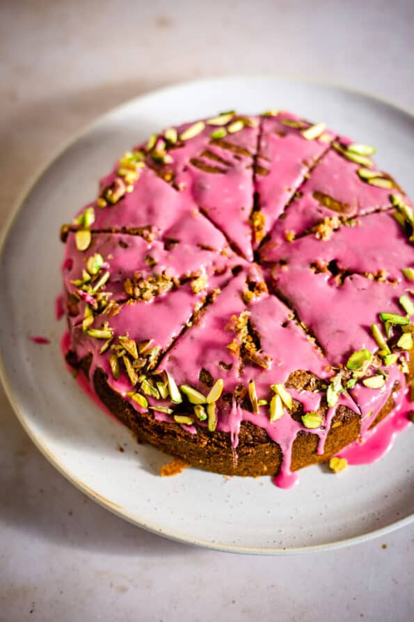 Raspberry Pistachio Cake cut into slices on a plate