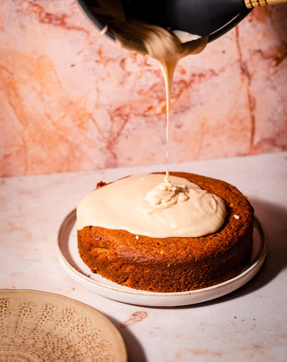 Pumpkin Cake with Maple frosting being poured on top