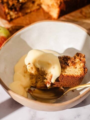 Apple crumble cake and custard in bowl