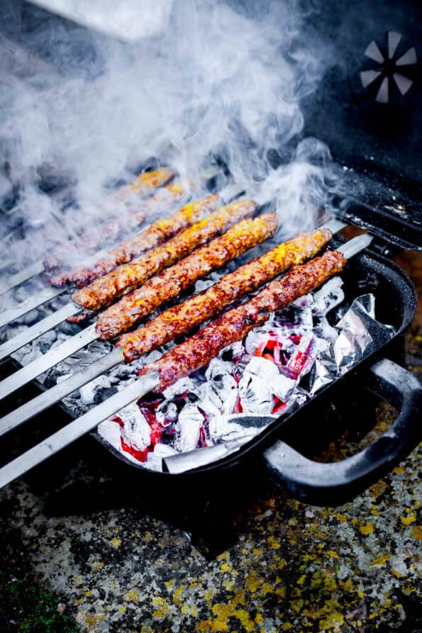 Kebabs smoking over barbequeue