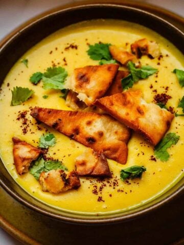 Shorbat adas in bowl with toppings